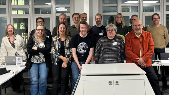 Gruppfoto med ett 15-tal människor i ett konferensrum