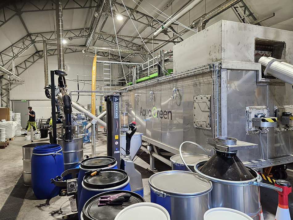 Industriell miljö med stora tunnor i rostfritt stål respektive knallblå plast